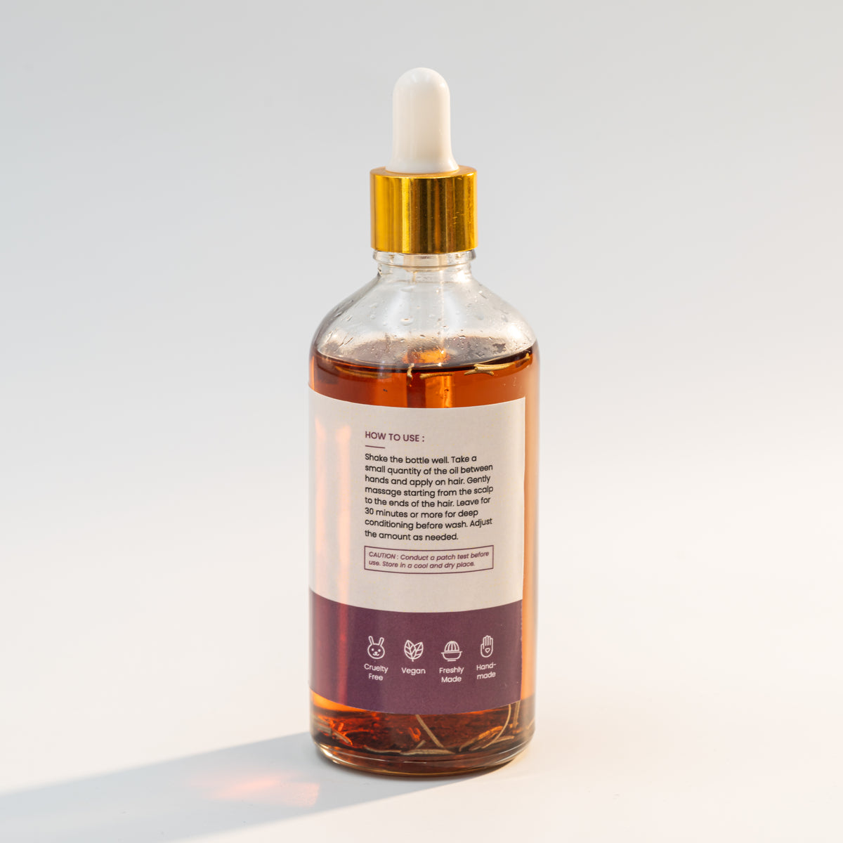 The premium glass bottle design of Linen Water Rosemary Moringa Hair Oil is shown with a natural environment.